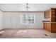 Living room with view of the kitchen area featuring wood cabinets, and a doorway at 95 Riverbrooke Trl, Covington, GA 30016