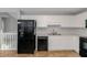 Practical kitchen featuring white cabinets, black appliances, and view of the staircase at 97 Spring Leaf Dr, Dallas, GA 30157