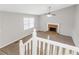 Living room boasts a brick fireplace and large window, viewed from the staircase at 97 Spring Leaf Dr, Dallas, GA 30157