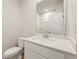 Clean powder room with a white vanity, mirror, toilet, and white walls at 4155 Viola Pl, Atlanta, GA 30349