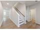 Bright hallway featuring wood-look flooring, a staircase with a wood handrail, and white walls at 4155 Viola Pl, Atlanta, GA 30349