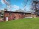 Backyard view of a two-story brick home with a wooden deck and lush lawn at 3230 Jamaica Nw Rd, Atlanta, GA 30318