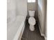 This is a bathroom with tiled walls, dark tiled floors, a bathtub and a toilet at 3230 Jamaica Nw Rd, Atlanta, GA 30318