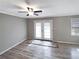 Bright living room with modern gray flooring, ceiling fan, and glass panel doors to the backyard at 3230 Jamaica Nw Rd, Atlanta, GA 30318