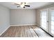 Bright living room with modern gray flooring, ceiling fan, and glass panel doors to the backyard at 3230 Jamaica Nw Rd, Atlanta, GA 30318