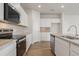 Kitchen with stainless appliances, granite countertops, white cabinets and hardwood flooring at 4163 Viola Pl, Atlanta, GA 30349