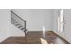 Bright living room featuring hardwood floors, a staircase, and a door leading to the outside at 482 Hammons Way, Atlanta, GA 30315