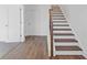 Staircase featuring durable laminate flooring on the steps and a wooden railing at 482 Hammons Way, Atlanta, GA 30315