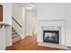 Cozy living room features fireplace with marble surround, wood floors, and staircase to upper level at 6080 Indian Wood Se Cir, Mableton, GA 30126