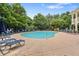 Large community swimming pool surrounded by lounge chairs and mature trees at 6080 Indian Wood Se Cir, Mableton, GA 30126