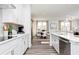 Bright kitchen with stainless appliances, white cabinets, quartz countertops, tile backsplash and view of dining room at 610 Belshire Dr, Acworth, GA 30102