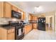 Well-equipped kitchen with black appliances, tile backsplash, and adjacent breakfast area at 3005 Bunchberry Ct, Ellenwood, GA 30294