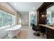 Bright bathroom with a soaking tub, glass shower, vanity and black chair beneath artwork at 4615 Northside Dr, Atlanta, GA 30327