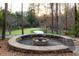 Outdoor fire pit with stone surround and built-in seating area on edge of putting green at 4615 Northside Dr, Atlanta, GA 30327