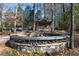 Charming outdoor fire pit with stone surround, wood storage and a cozy cabin in the background at 4615 Northside Dr, Atlanta, GA 30327