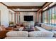 Comfortable living room featuring plush seating, hardwood floors, beamed ceilings, and a large window at 4615 Northside Dr, Atlanta, GA 30327