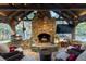 Outdoor stone fireplace under post and beam roof with pizza oven, lighting, and comfortable seating at 4615 Northside Dr, Atlanta, GA 30327
