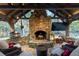 Outdoor fireplace with pizza oven, comfortable seating, and wooded views at 4615 Northside Dr, Atlanta, GA 30327