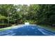 Well-maintained tennis court featuring a blue and green surface, surrounded by mature trees at 4615 Northside Dr, Atlanta, GA 30327