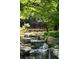 Water cascades over natural rocks, adding a touch of serenity to the yard at 4615 Northside Dr, Atlanta, GA 30327