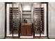This luxurious wine room features custom shelving, glass doors, and a central cabinet for storing wine and glasses at 4615 Northside Dr, Atlanta, GA 30327
