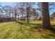 The grassy backyard, flanked by mature trees, offers space for outdoor activities and relaxation at 1890 Carla Dr, Morrow, GA 30260