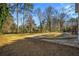 Large backyard surrounded by mature trees with a concrete slab at 1890 Carla Dr, Morrow, GA 30260