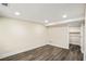 Basement room with wood-look flooring, bright recessed lighting, and a doorway to a storage area at 1890 Carla Dr, Morrow, GA 30260