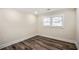 View of an empty bedroom with wood-look flooring, a window, and neutral-toned walls at 1890 Carla Dr, Morrow, GA 30260