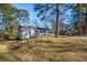 White home with a carport is set among mature trees on a lush, grassy lot at 1890 Carla Dr, Morrow, GA 30260