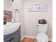 Cozy half bath with wood look flooring and a decorative bird themed picture at 2333 Sheridan Ct, Villa Rica, GA 30180