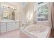 Bathroom featuring a soaking tub, a vanity with white cabinets and a large mirror at 2333 Sheridan Ct, Villa Rica, GA 30180