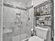 Modern bathroom featuring a glass enclosed shower with tiled walls and floor, along with sleek shelving at 360 Chimney Ct, Fairburn, GA 30213