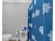 Close-up on a modern bathroom featuring decorative blue shower curtain and updated fixtures and accessories at 360 Chimney Ct, Fairburn, GA 30213