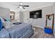 Stylish bedroom with decorative brick wall in adjoining bathroom area, large TV, and stylish decor at 360 Chimney Ct, Fairburn, GA 30213