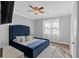 Inviting bedroom with blue upholstered bed, plush rug, and natural light streaming through the window at 360 Chimney Ct, Fairburn, GA 30213