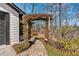 A charming home entrance features a stone path, a pergola covered in vines, and lush landscaping at 360 Chimney Ct, Fairburn, GA 30213