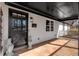 Spacious covered front porch featuring a dark-stained wood door with glass panes and vintage sconce light at 360 Chimney Ct, Fairburn, GA 30213