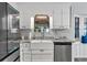 Close-up of a kitchen sink with granite countertops, stainless steel dishwasher, and bright window at 360 Chimney Ct, Fairburn, GA 30213