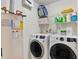 Bright laundry room with washer, dryer, water heater, and ample shelving for storage and supplies at 360 Chimney Ct, Fairburn, GA 30213