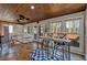 An open living room features a wood ceiling, flagstone floors, and multiple windows providing natural light and views at 360 Chimney Ct, Fairburn, GA 30213