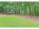 Expansive backyard with green lawn surrounded by trees at 3625 N Berkeley Lake Nw Rd, Berkeley Lake, GA 30096