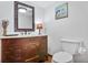 Charming bathroom featuring a vintage vanity, framed mirror, and elegant decorative accents at 3625 N Berkeley Lake Nw Rd, Berkeley Lake, GA 30096