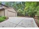 View of a long concrete driveway leading up to a two car attached garage at 3625 N Berkeley Lake Nw Rd, Berkeley Lake, GA 30096