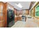 Functional kitchen with stainless steel appliances, wood cabinets, and bright lighting at 3625 N Berkeley Lake Nw Rd, Berkeley Lake, GA 30096