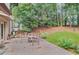 A backyard patio area with table and chairs, and natural landscaping at 3625 N Berkeley Lake Nw Rd, Berkeley Lake, GA 30096