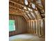 A framed bedroom with high ceilings and a window, representing the early stages of building at 3790 Chattahoochee (Lot 33) Rd, Cumming, GA 30041