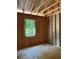 Bedroom under construction with a window overlooking green scenery, in mid-build stage at 3790 Chattahoochee (Lot 33) Rd, Cumming, GA 30041
