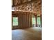 Unfinished room with wooden flooring and three windows overlooking a wooded lot at 3790 Chattahoochee (Lot 33) Rd, Cumming, GA 30041
