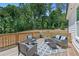 Outdoor deck area with wicker seating arrangement and wooded backyard at 3790 Chattahoochee (Lot 33) Rd, Cumming, GA 30041